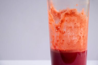 Bir bardak taze havuç, izole bir arka planda pancar suyu.