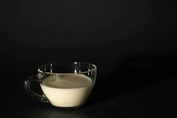 Vaso con leche sobre un fondo oscuro aislado —  Fotos de Stock