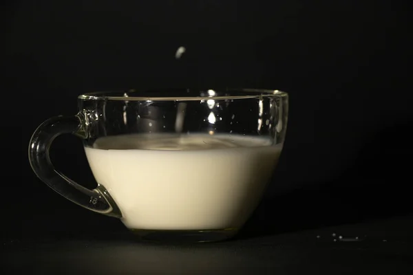 Glas met melk op een donkere geïsoleerde achtergrond — Stockfoto