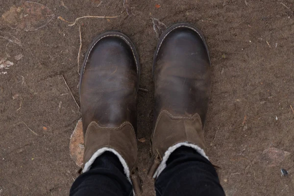 Winter boots on the feet of a girl on the ground top view — Stock Photo, Image