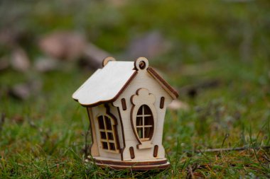 Tahta bebek evi yeşil çimlerin üzerinde duruyor.