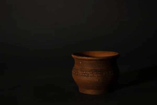 Глиняна маленька чашка на темному ізольованому фоні — стокове фото