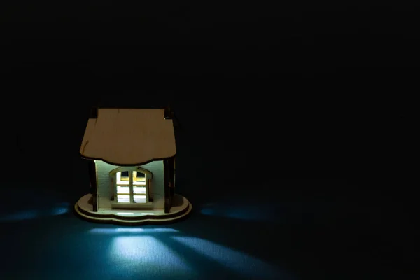 Light comes out of the window of a wooden house in the dark — 스톡 사진