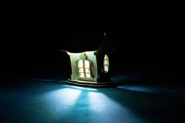 Licht kommt im Dunkeln aus dem Fenster eines Holzhauses — Stockfoto