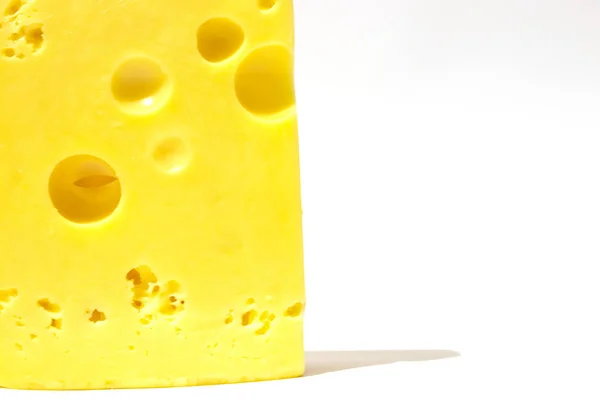 Trozo de queso sobre un fondo blanco aislado — Foto de Stock