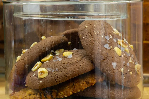 Um jarro de vidro de biscoitos de batata frita de chocolate está em uma mesa — Fotografia de Stock