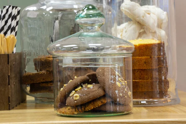 Стеклянная банка шоколадного печенья стоит на столе — стоковое фото