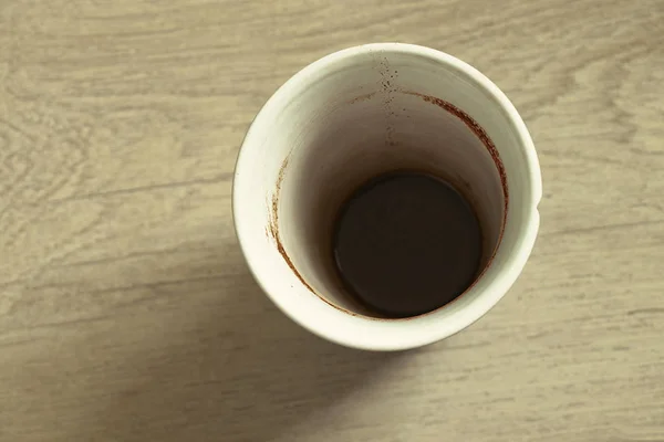 Una taza de café sucia vacía está sobre una mesa de madera —  Fotos de Stock