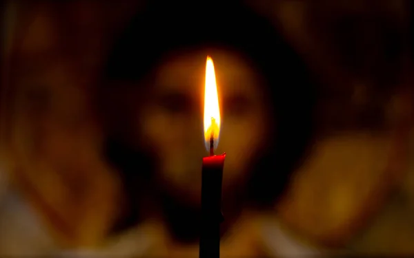 Bougie allumée illumine l'icône de Jésus-Christ dans l'obscurité — Photo