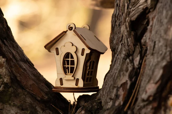 Небольшой деревянный домик на ветвях елки — стоковое фото