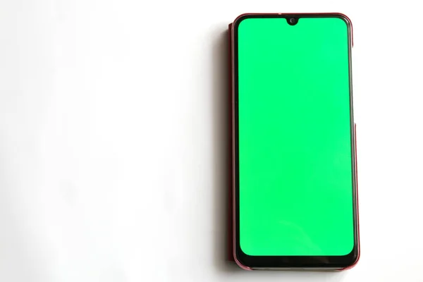 Touchscreen telefoon met een groen scherm op een witte achtergrond — Stockfoto