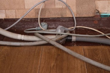 electric wires and drain hoses are on the old dirty floor