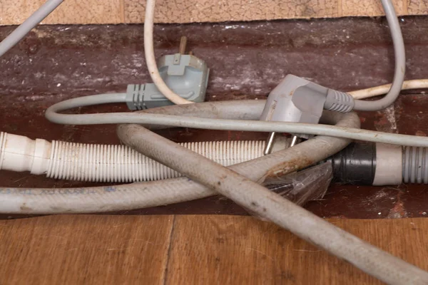 Електричні дроти і зливні шланги на старій брудній підлозі — стокове фото