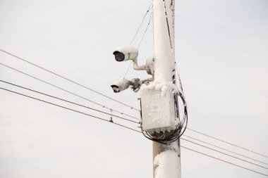 video camera on a pillar in the winter in the city