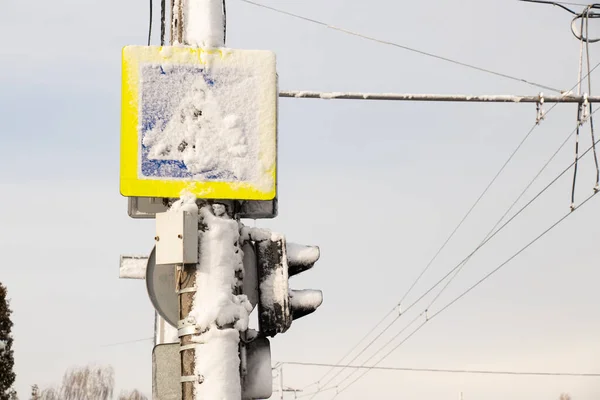 Светофор и дорожный знак на снегу в зимний день — стоковое фото