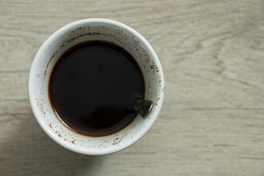 cup with coffee stands on a wooden table