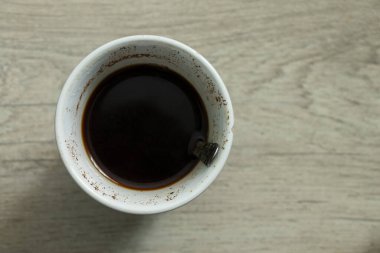 cup with coffee stands on a wooden table