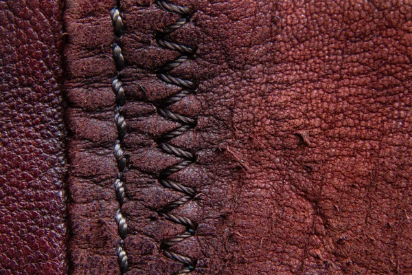 Achtergrond van rode huid en naad closeup — Stockfoto