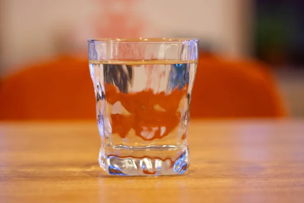 Un vaso de agua sobre una mesa de madera —  Fotos de Stock