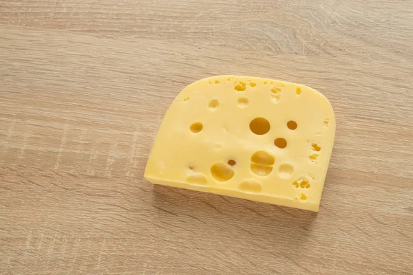 Stuk kaas op een houten achtergrond — Stockfoto