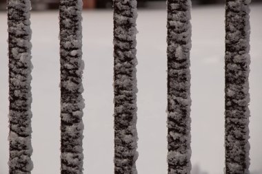 Kışın sokakta buzun içinde metal çitler