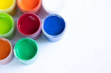 Suluboya tablolar gün ışığında bir masanın üzerinde duruyor.