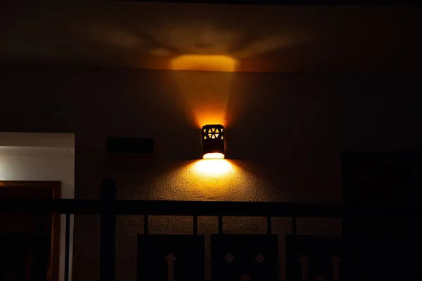 Lustre na parede em um quarto escuro dentro de casa — Fotografia de Stock
