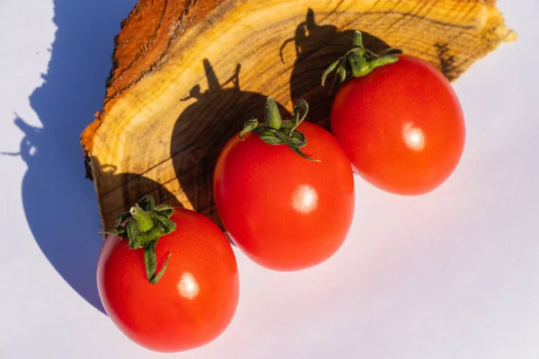 red cherry tomatoes on a wooden old chopper in daylight close-up