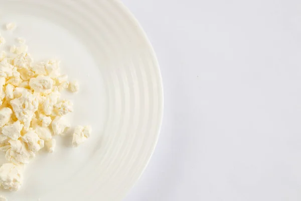 sour milk cottage cheese in a white bowl on a white background close-up