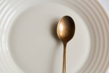 İzole edilmiş arka planda beyaz tabak ve çay kaşığı