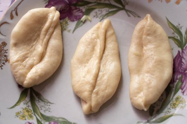 Evde masanın üzerinde patatesli çiğ turta yatıyor.