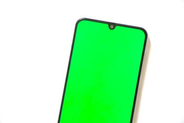 Dokunmatik ekranlı telefon, arka planda yeşil ekran var.