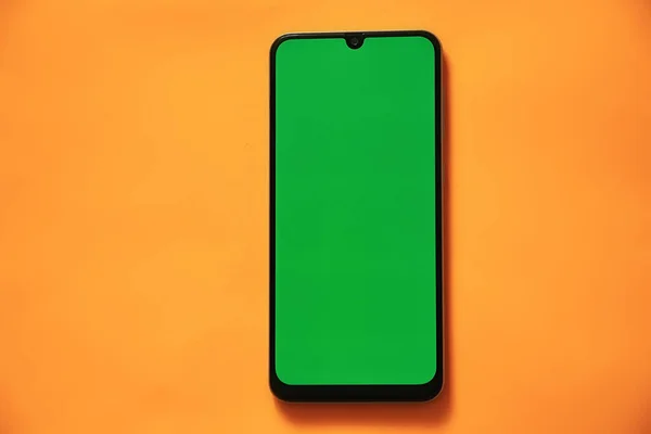 touchscreen phone with a green screen on a light background