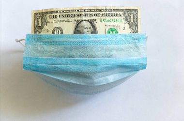 Tıbbi maske beyaz bir doların üzerinde.