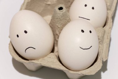 Beyaz bir yumurta, gözler ve ağız izole bir arka planda siyah bir keçeli kalemle çizilir.