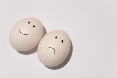 Beyaz bir yumurta, gözler ve ağız izole bir arka planda siyah bir keçeli kalemle çizilir.