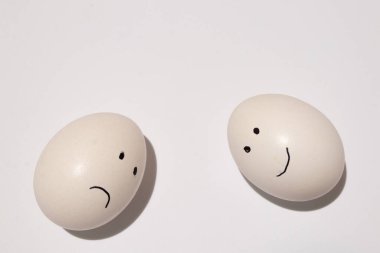 Beyaz bir yumurta, gözler ve ağız izole bir arka planda siyah bir keçeli kalemle çizilir.