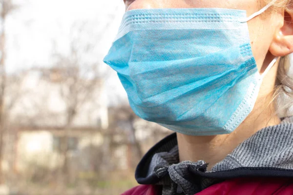 Yüzünde tıbbi maske olan Ukraynalı genç bir kadının yakın plan fotoğrafı.