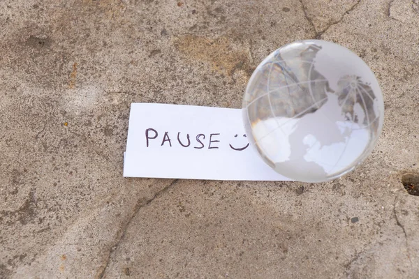 the word pause in English and a glass globe