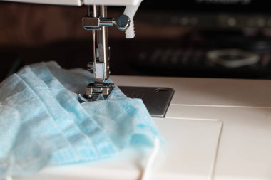 Yeni dikiş makinesi yakın çekim sırasında tıbbi maske dikiyor