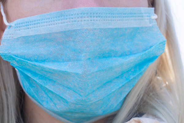 closeup of a young Ukrainian woman in a medical mask on her face during the pandemic outdoors