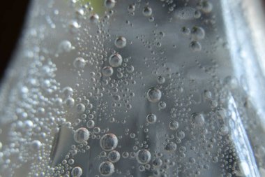 Plastik şişe makro fotoğrafına su damlıyor.