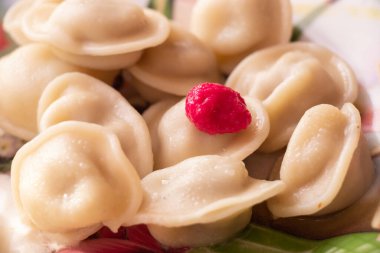 Yemek masasında çatalla birlikte bir tabakta pişmiş hamur köftesi.