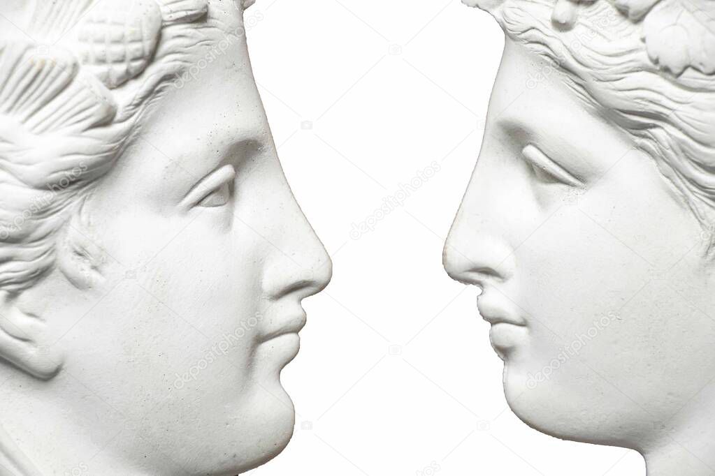 two faces of a gypsum statue in profile on an isolated background