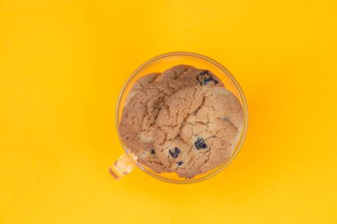 Turuncu arka planda bir fincan dolusu kurabiye.