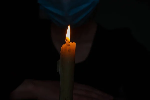 在黑暗的房间里 戴着医疗面罩 背靠着燃着的蜡烛的女孩 — 图库照片