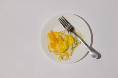 İzole edilmiş bir arka planda çatallı bir tabakta yumurta.