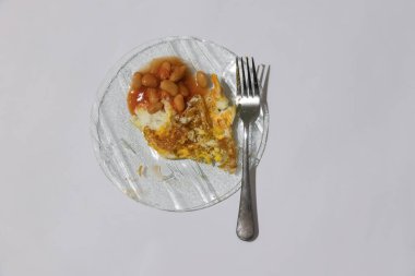 Tenha bir zeminde çatalla domatesli yumurta ve fasulye.