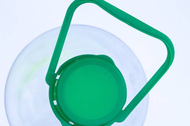 Beyaz arka planda kapaklı plastik şişe.