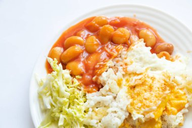 Domatesli kızarmış yumurta ve tenha bir arka planda kabuklu lahana salatası.